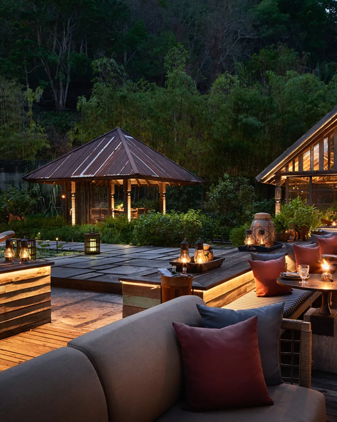 A lantern-lit garden terrace and open-sided pavilion at dusk, Rosewood Chiang Mai