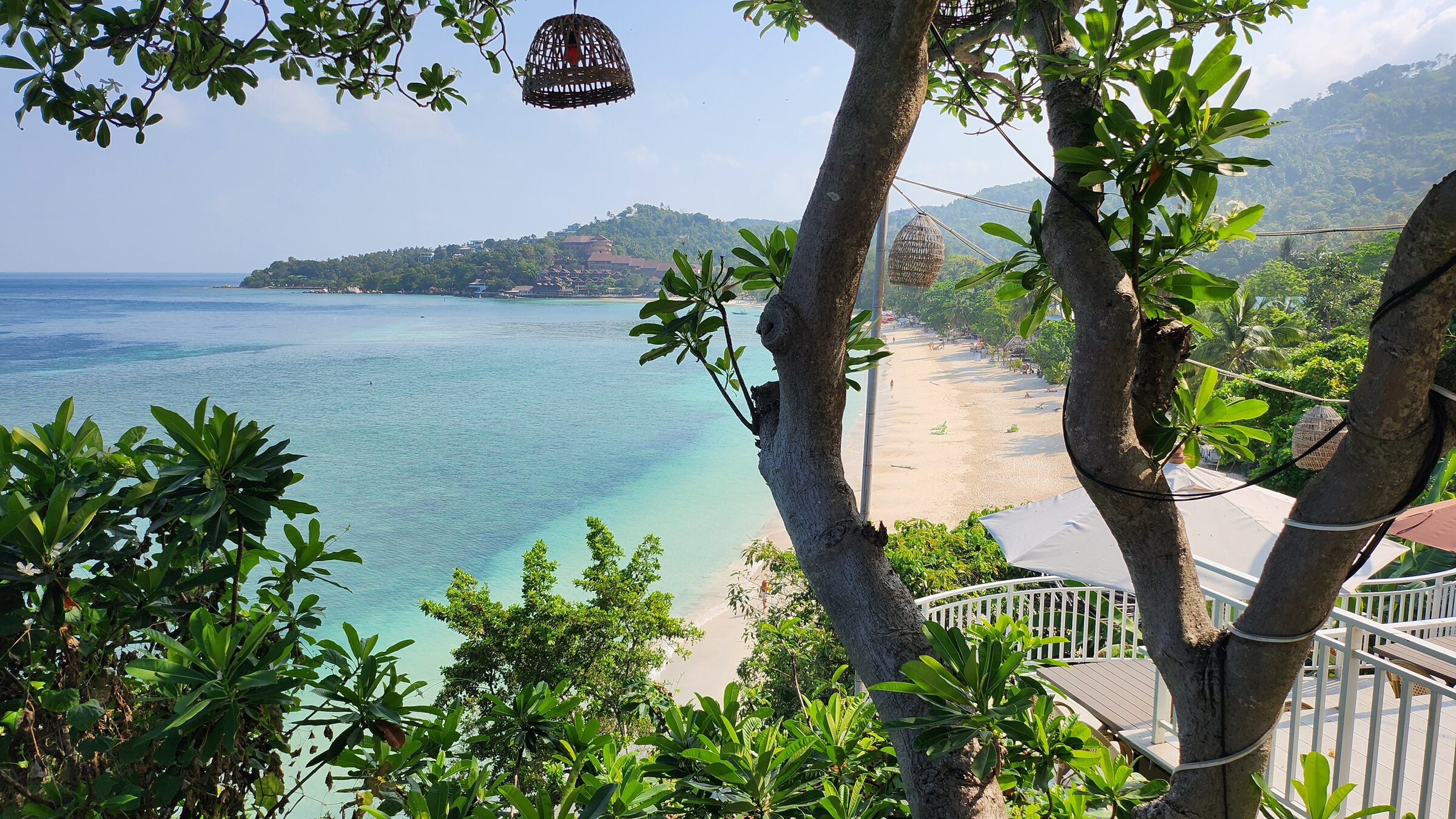 The curve of Haad Yao beach from the headland, pale sand and turquoise shallows, Koh Phangan