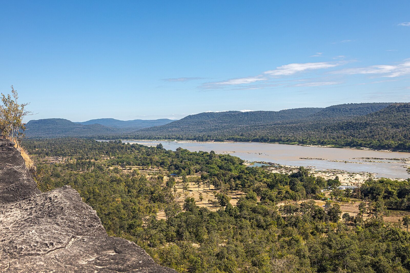 The Mekong River valley seen from the cliff edge at Pha Taem, forested hills beyond