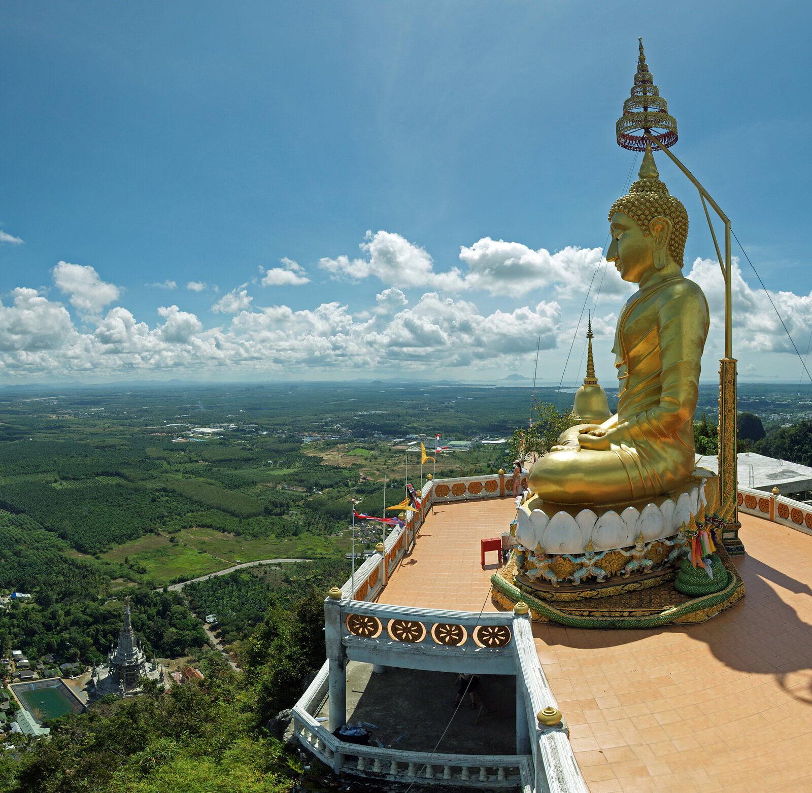 The gold Buddha atop Tiger Cave Temple's summit, the Krabi plain stretching below