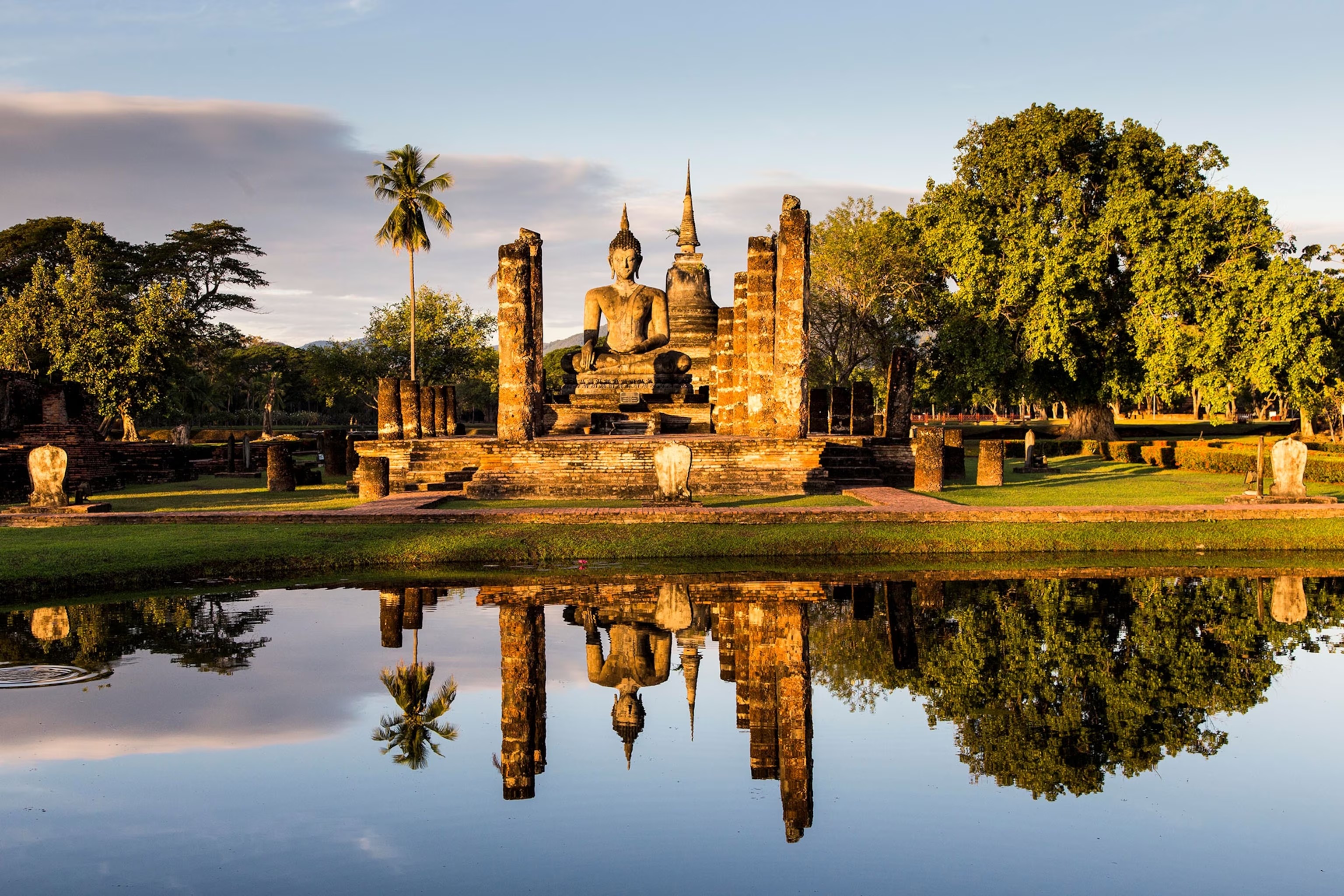 Sukhothai Historical Park reflected in its still water at dusk
