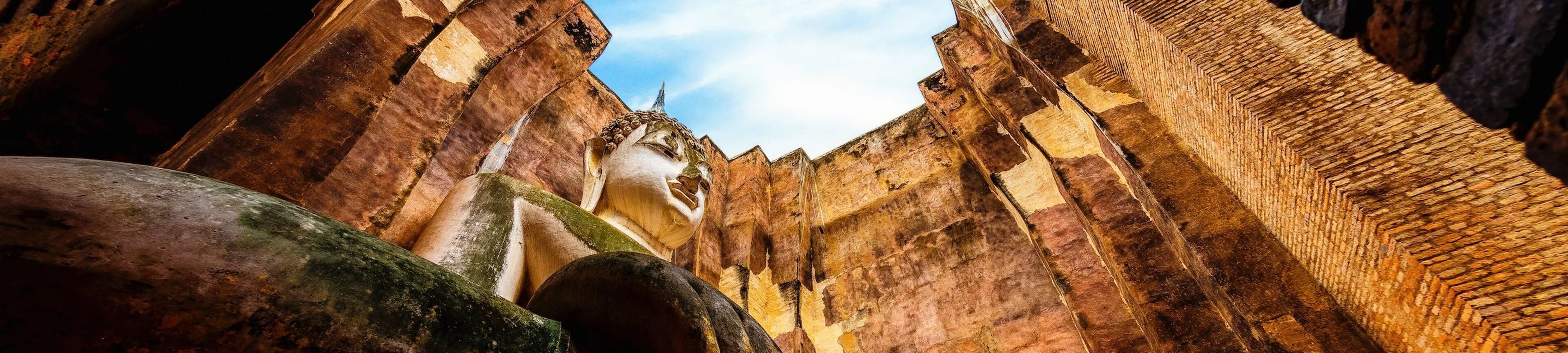 A seated Buddha framed by ancient brick walls, Sukhothai