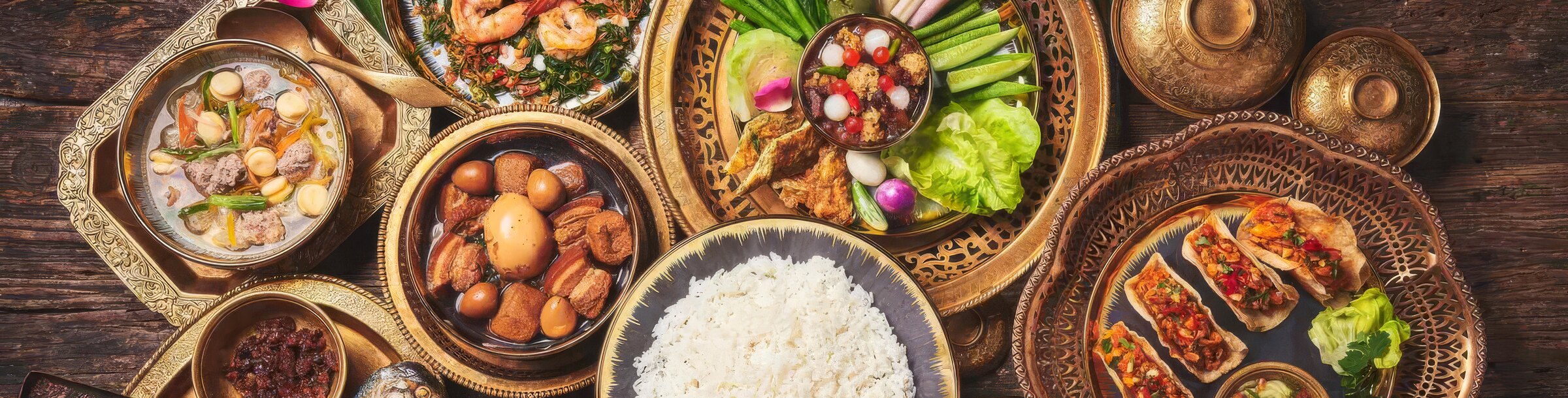 A traditional Lanna khantoke spread of northern Thai dishes in brass bowls